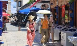 Antalya sıcağında ilginç görüntü! Uzak Doğulu turistler yüzlerini kapattı